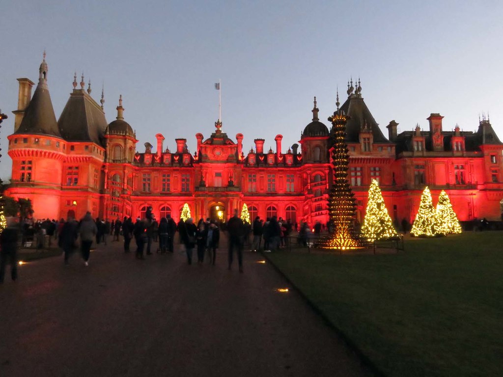 Waddesdon Manor at dusk with warm windows glowing.
